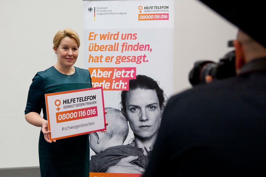 Dr. Franziska Giffey hält das Schild mit der Telefonnummer des Hilfetelefons hoch: 08000/116016