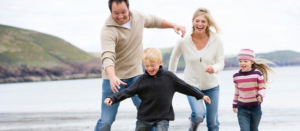 Porträt einer spielenden Familie am Strand