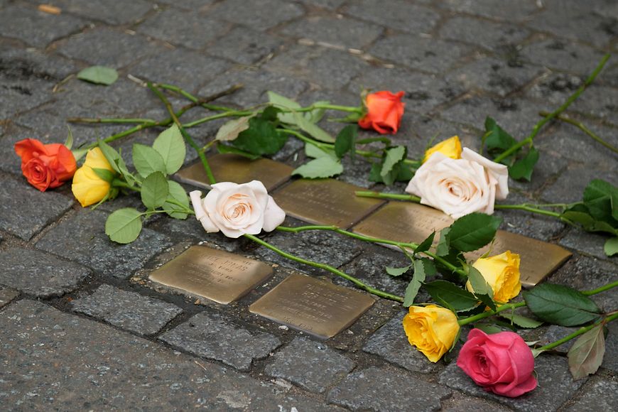 Rosen sind an mehreren Stolpersteinen niederlegt