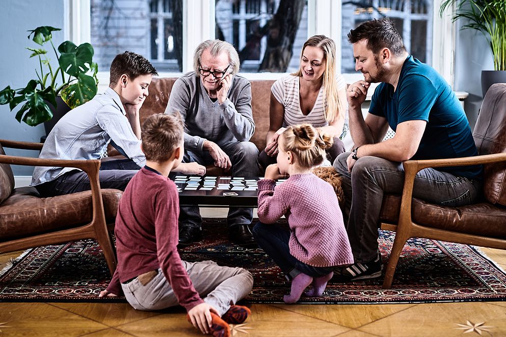 Eine Familie sitzt am Tisch und spielt 