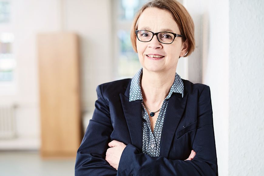 Eine Frau lehnt sich an eine Wand 