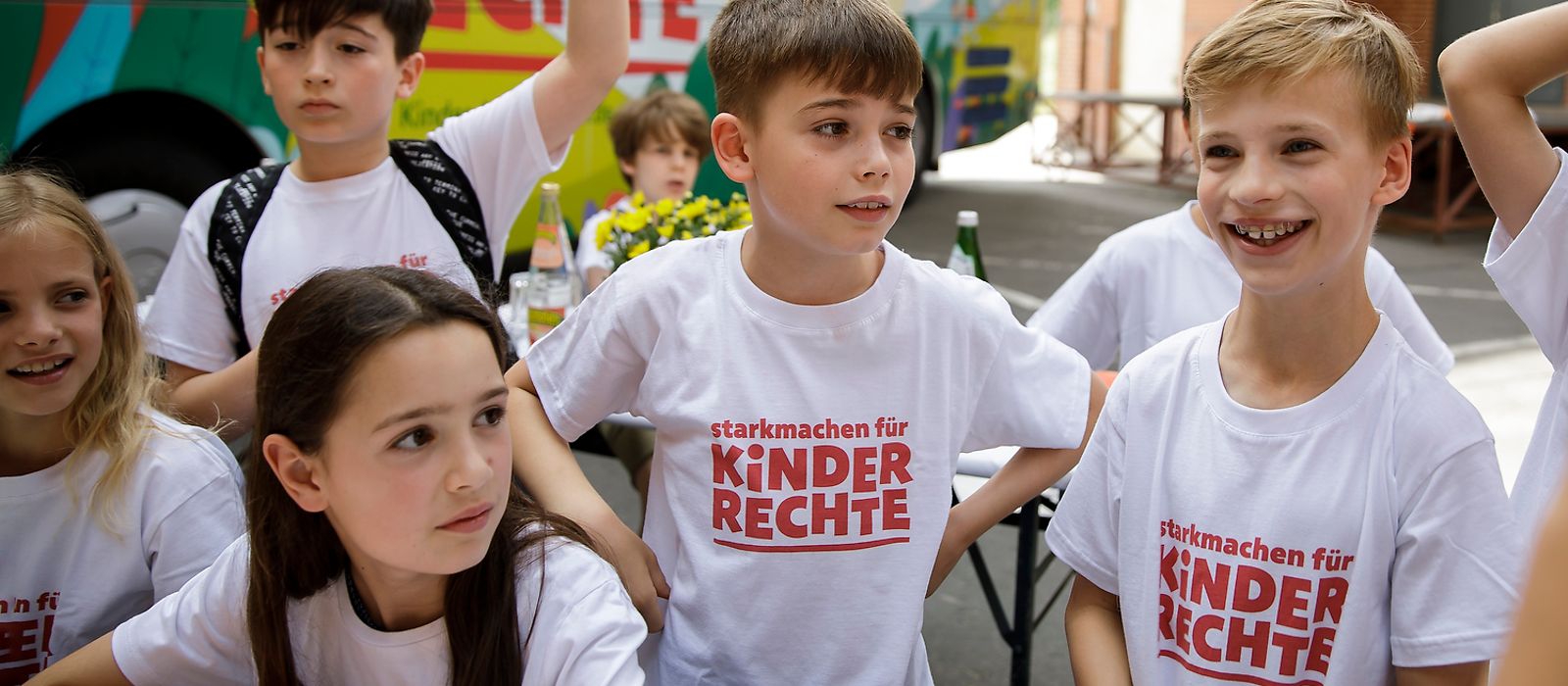 Kinder tragen ein T-Shirt "Starkmachen für Kinderrechte"