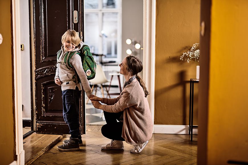 Eine Mutter verabschiedet ihr schulpflichtiges Kind