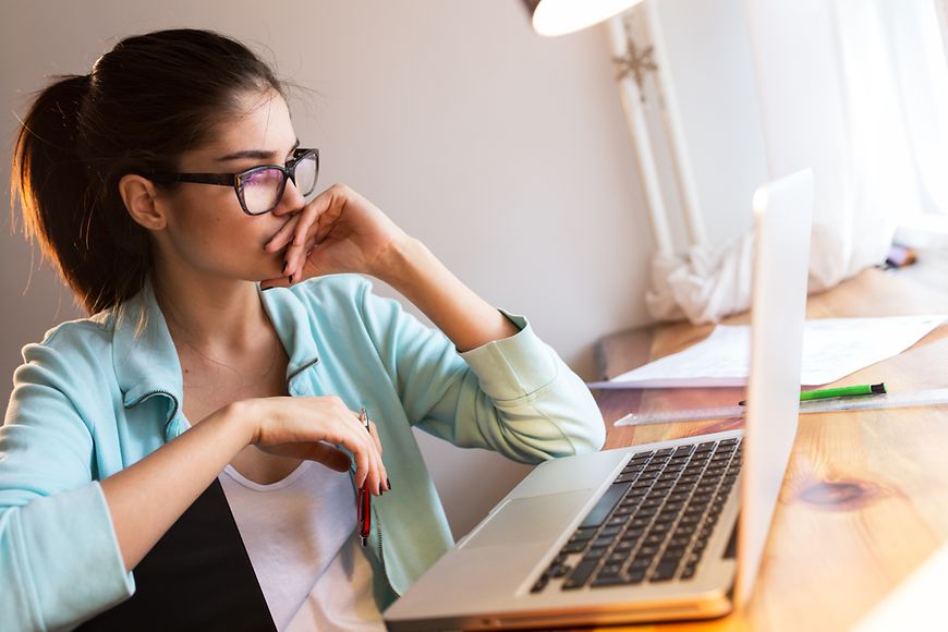 Eine Frau sitzt zuhause am Laptop 