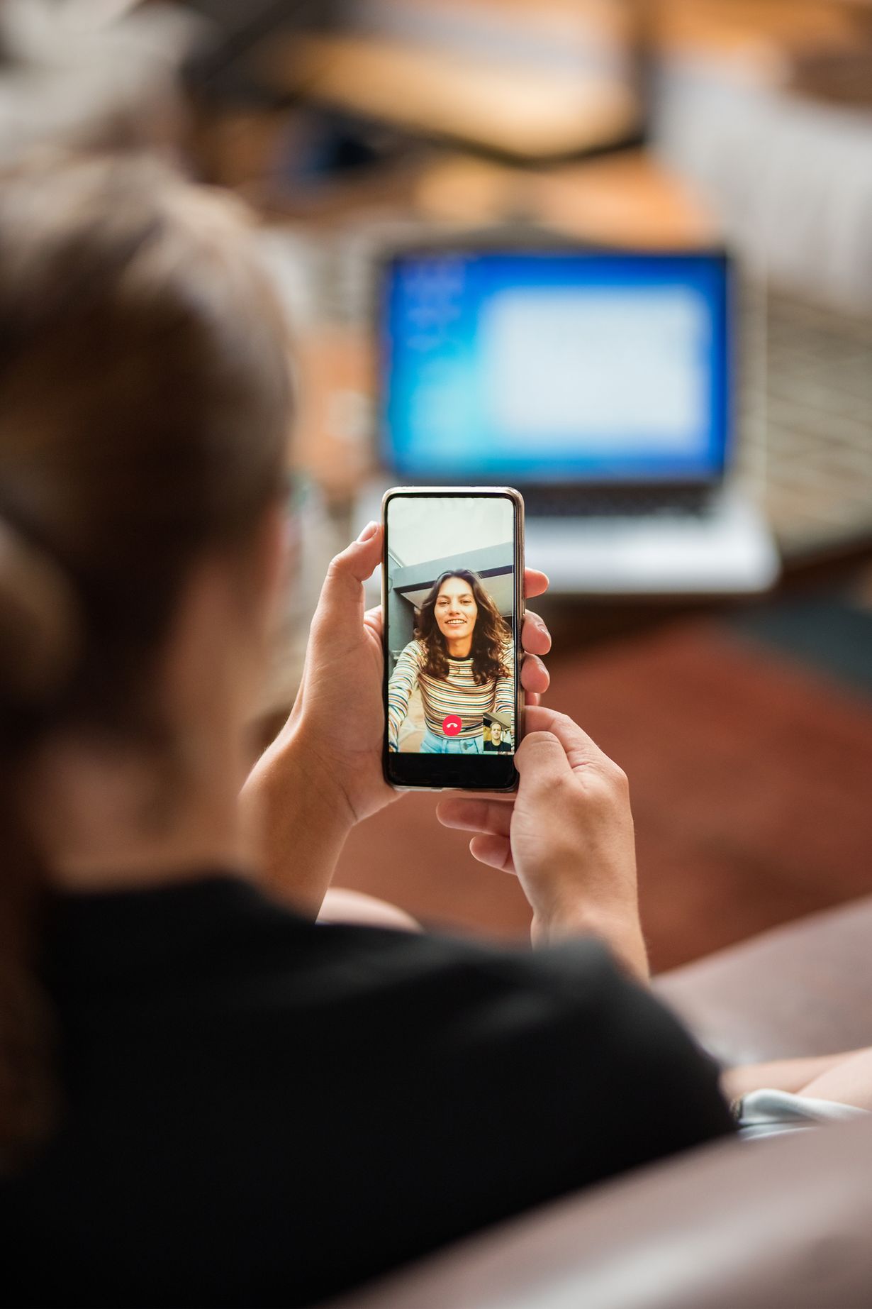 Eine junge Frau bei einem Videotelefonat mit einer anderen Frau