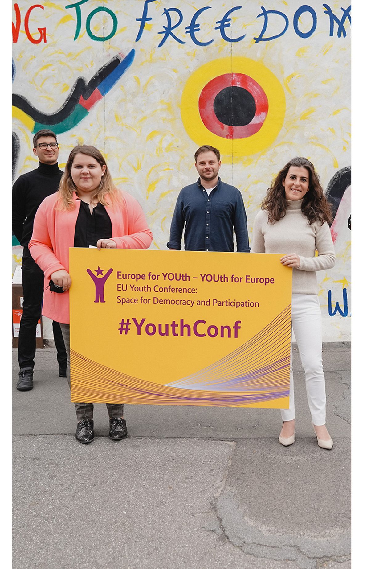 Jugendliche halten ein Plakat des Europäischen Jugenddemokratiekongresses hoch
