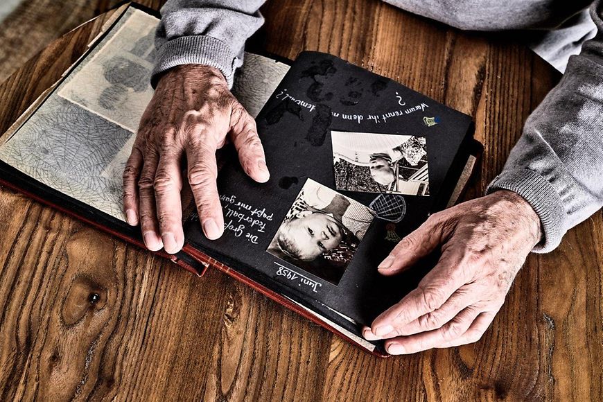 Älterer Mann schaut sich ein Fotoalbum an 