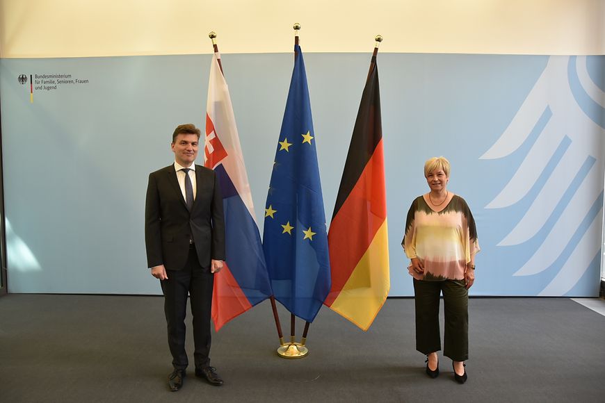 Caren Marks und der slowakische Botschafter Marián Jacubócy im Bundesfamilienministerium vor einer blauen Wand