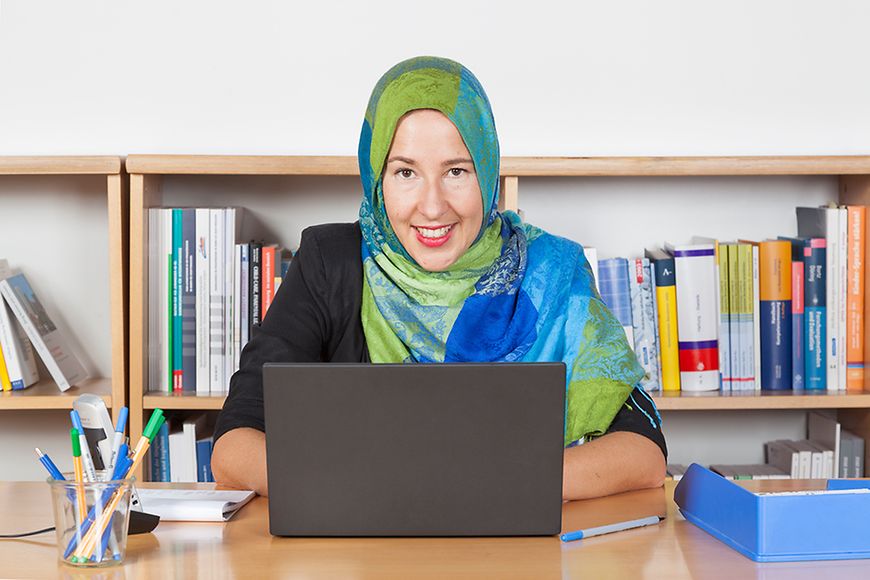 Eine zugewanderte Frau sitzt vor ihrem Laptop