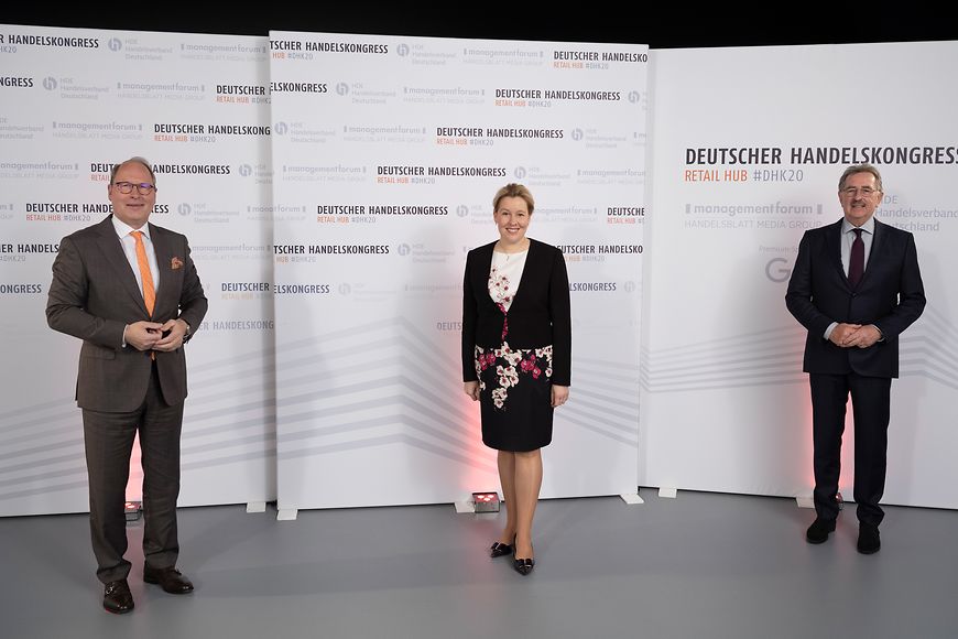 Franziska Giffey, Stefan Genth und Josef Sanktjohanser vor einer Wand mit der Aufschrift deutscher Handelskongress
