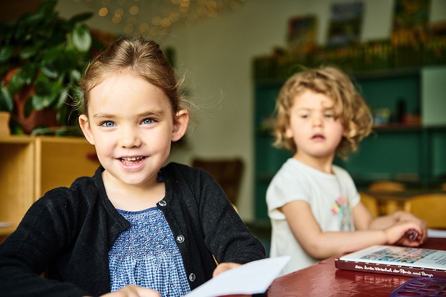 Zwei kleine Mädchen sitzen an einem Tisch