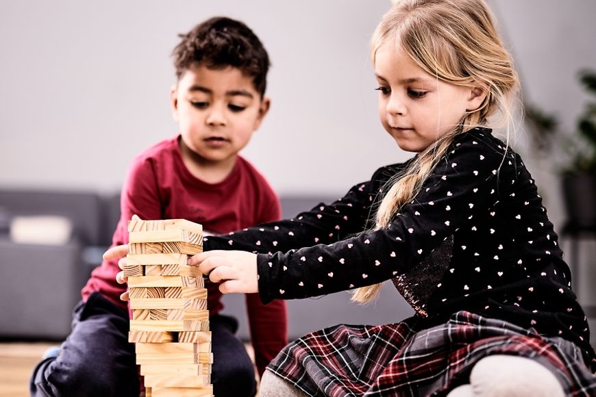 Zwei Kinder spielen zusammen in einem Wohnzimmer