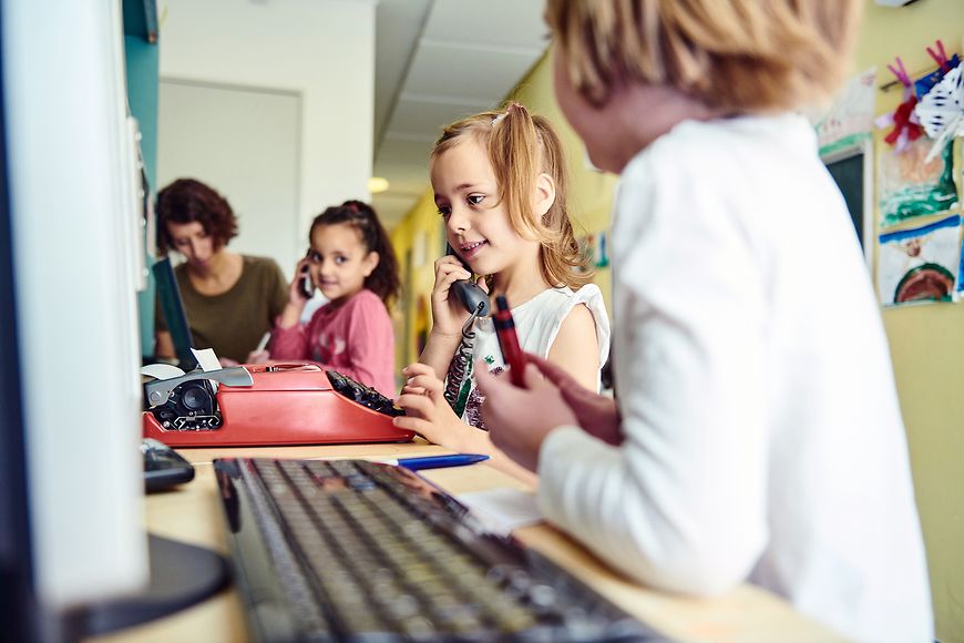 Kinder sitzen vor Computern