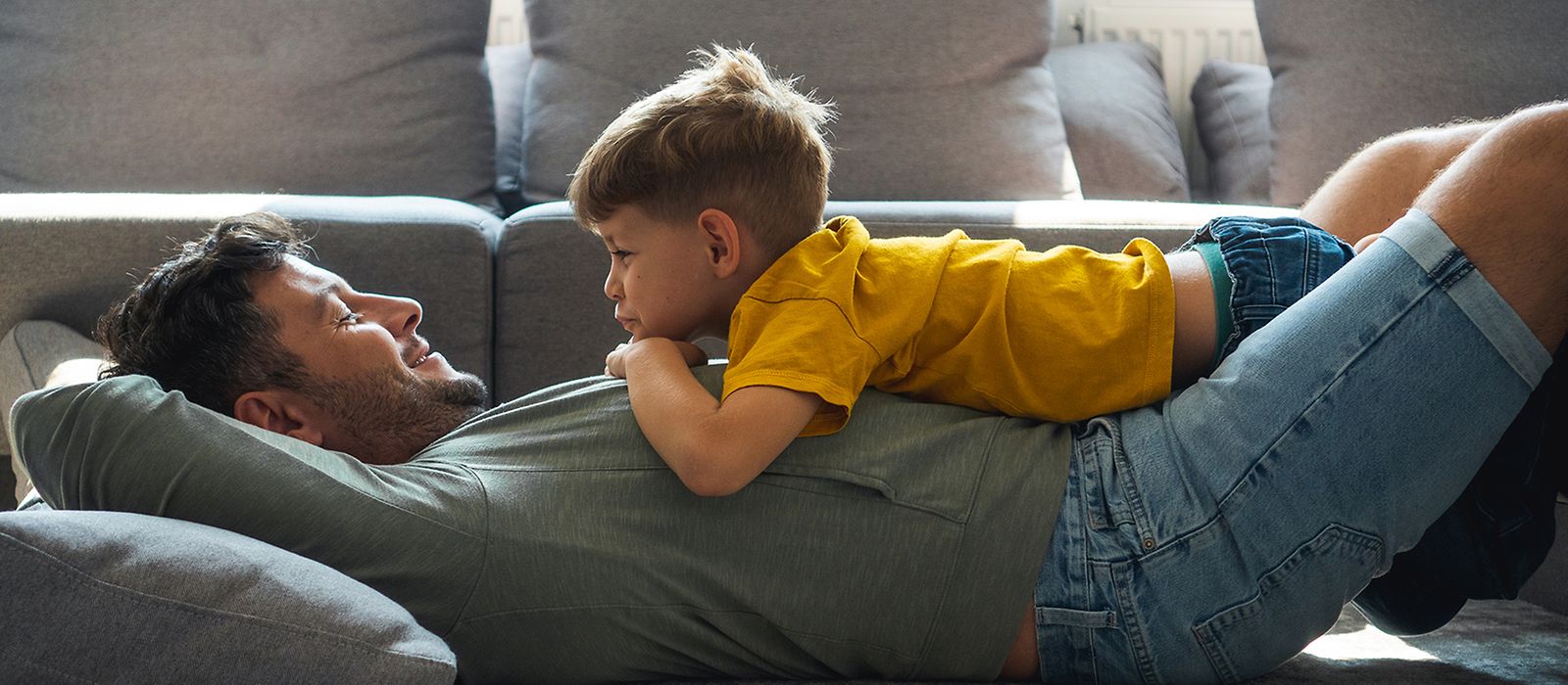 Vater und Sohn liegen zusammen auf dem Sofa