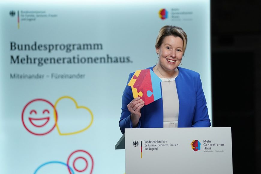 Franziska Giffey am Redepult vor einer Präsentation zum Bundesprogramm Mehrgenerationenhaus