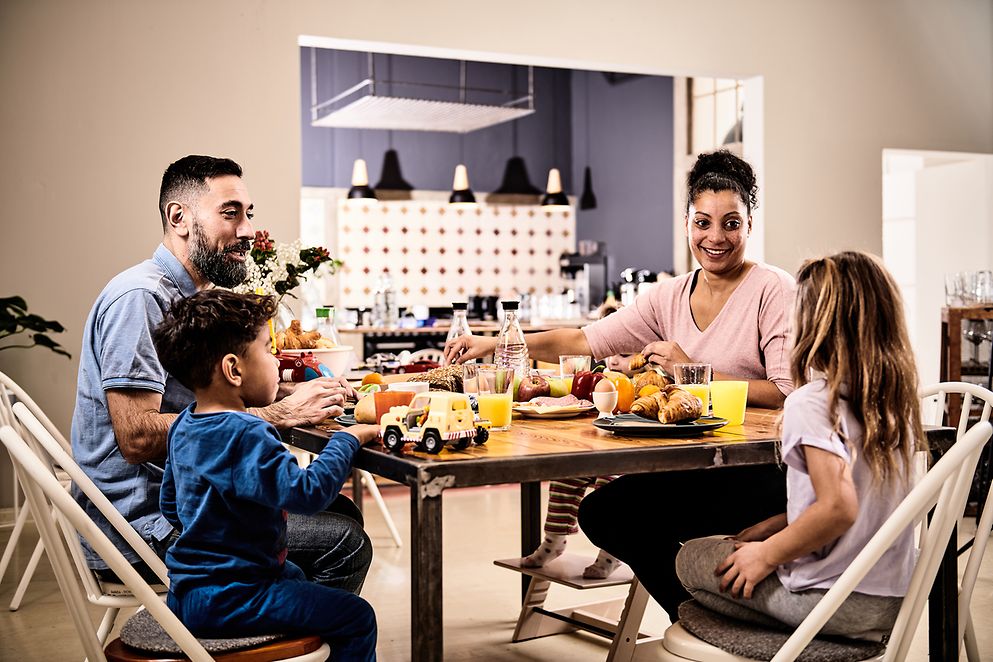 Eine Familie mit zwei Kindern sitzt am Küchentisch