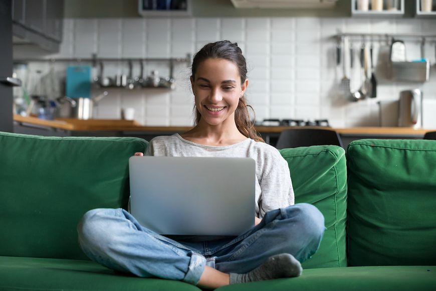 Eine Frau am Laptop auf einem Sofa