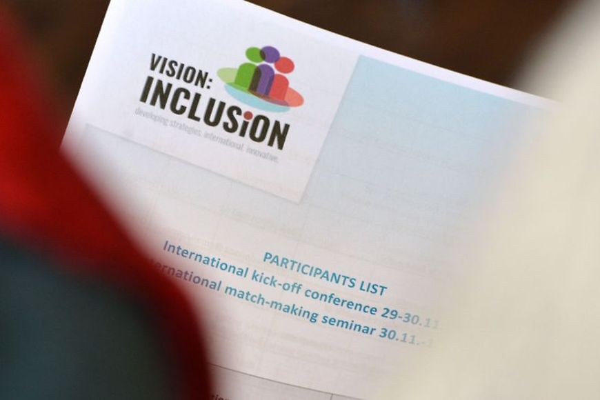 Foto in ein Heft, auf dem steht: Projekt VISION:INCLUSiON