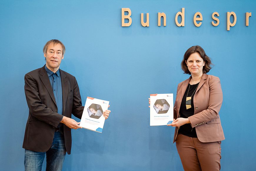 Thomas Krüger vom DKHW und Juliane Seifert mit dem Kinderreport 2021 in der Bundespressekonferenz