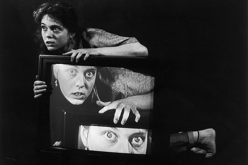 Schwarzweiß-Foto einer junger Frau mit Fernseher