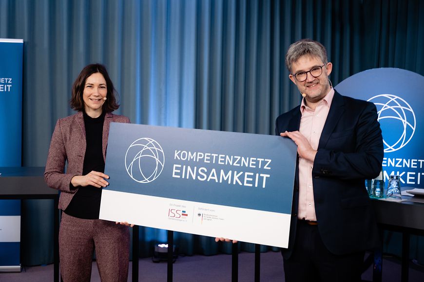 Anne Spiegel und Benjamin Landes halten eine Tafel hoch mit der Aufschrift Kompetenznetz Einsamkeit