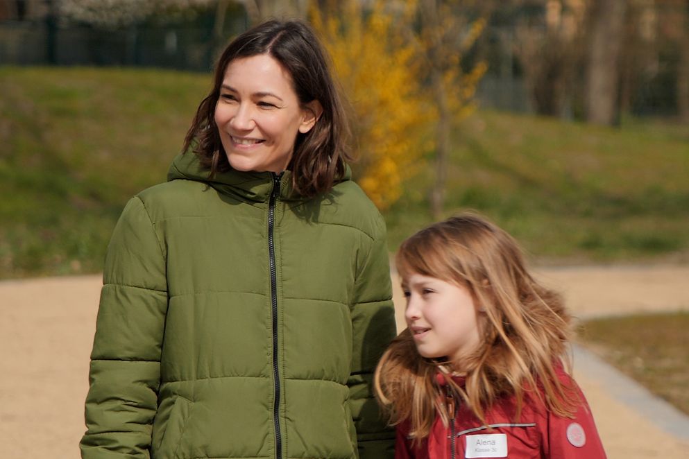 Bundesjugendministerin Anne Spiegel mit einer Schülerin auf dem Spielplatz der Schule