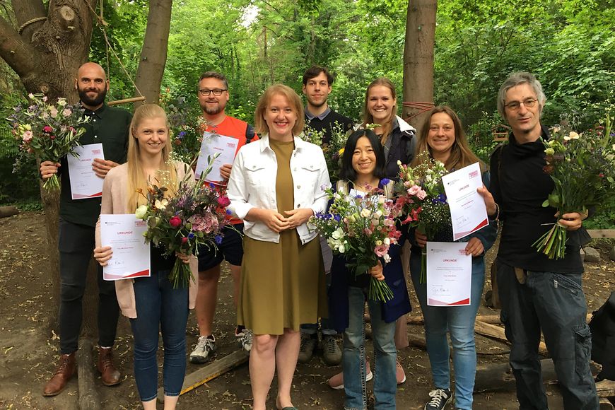 Gruppenfoto mit Lisa Paus und Absolventinnen der Fachkräfteoffensive Erzieherinnen und Erzieher in einer Berlin Kita - außen