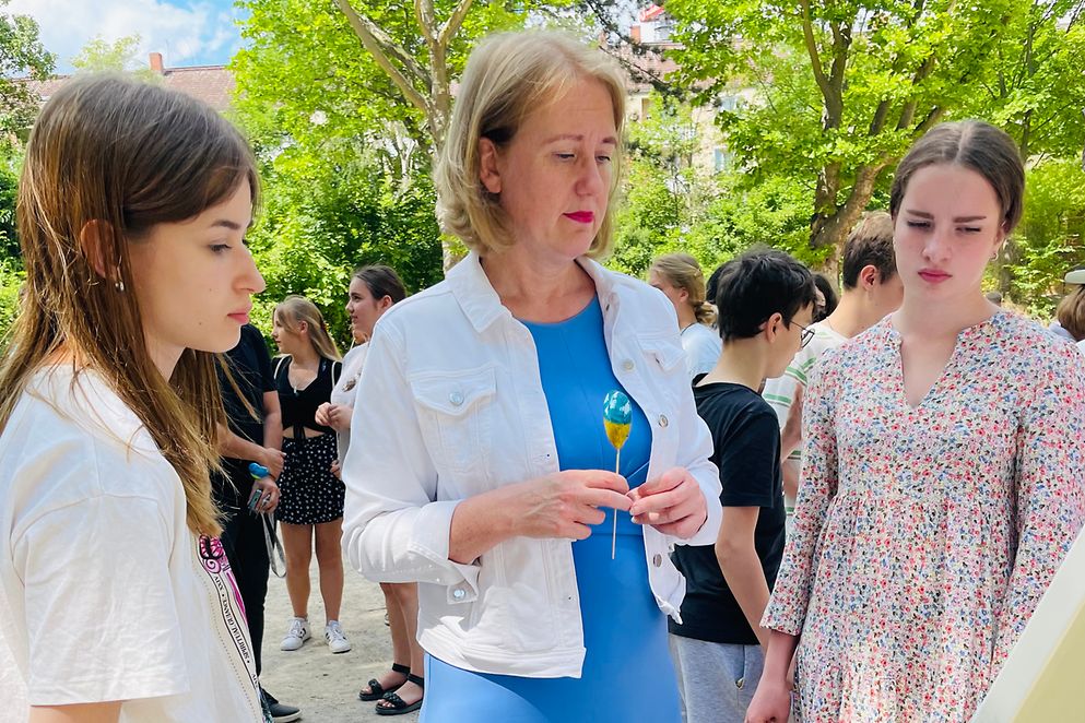 Lisa Paus im Freien im Austausch mit Schülerinnen aus der Ukraine