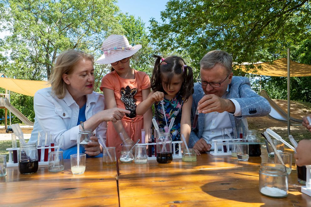 Lisa Paus und Michael Fritz mit Kindern in der Fröbel-Kita in Berlin experimentieren im Freien