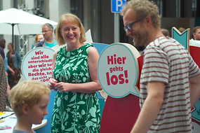 Bundesfamilienministerin Lisa Paus steht inmitten interessierter Bürgerinnen und Bürger