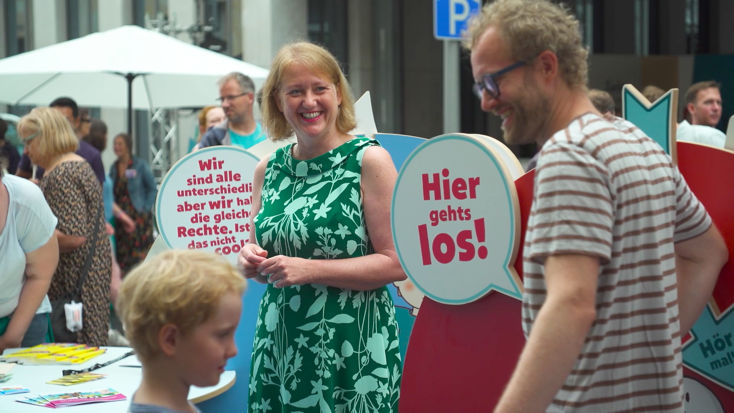 Bundesfamilienministerin Lisa Paus steht inmitten interessierter Bürgerinnen und Bürger