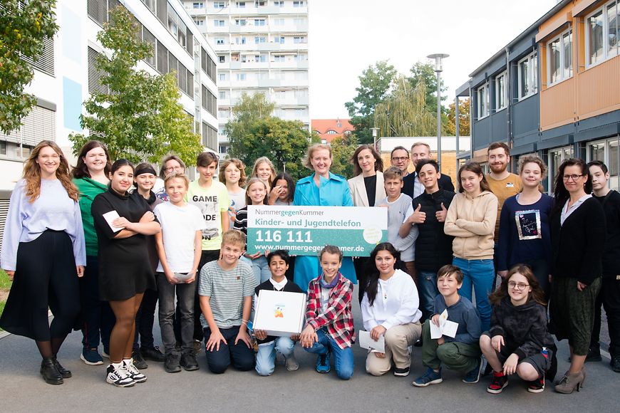 Lisa Paus sitzt im Stuhlkreis und spricht über die Schulbox zur "Nummer gegen Kummer"