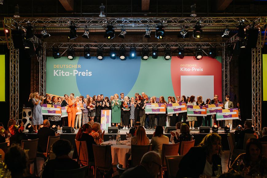 Die Preisverleihung des Deutschen Kita-Preises: Lisa Paus steht mit den Empfänger:innen auf einer Bühne