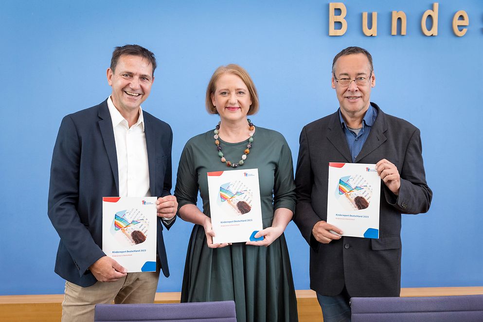 Holger Hofmann, Lisa Paus und Thomas Krüger mit dem Kinderreport 2023 des Deutschen Kinderhilfswerkes