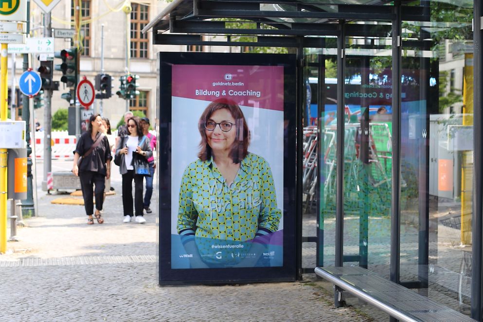 Plakatmotiv zur Bildungskampagne "Wissen für alle" an einer Bushaltestelle