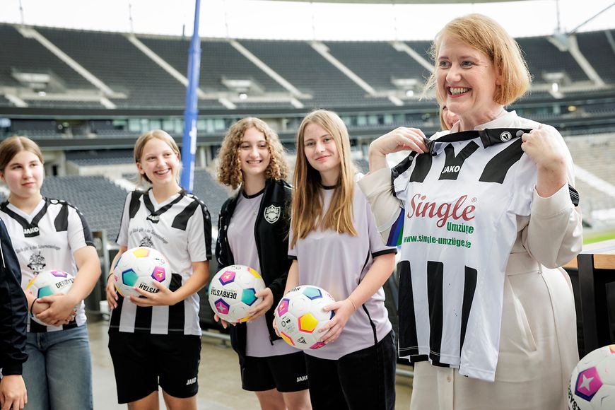 Lisa Paus mit Nachwuchsfussballspielerinnen auf der Stadiontribüne 