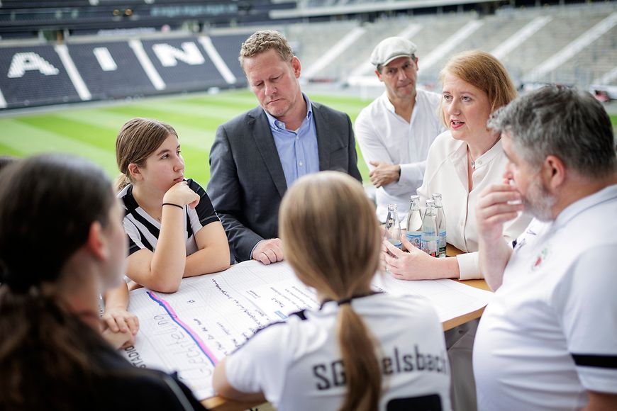 Lisa Paus mit Nachwuchsspielerinnen in einer Gesprächsrunde