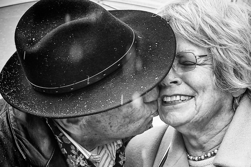 Ein älterer Mann küsst eine ältere Frau
