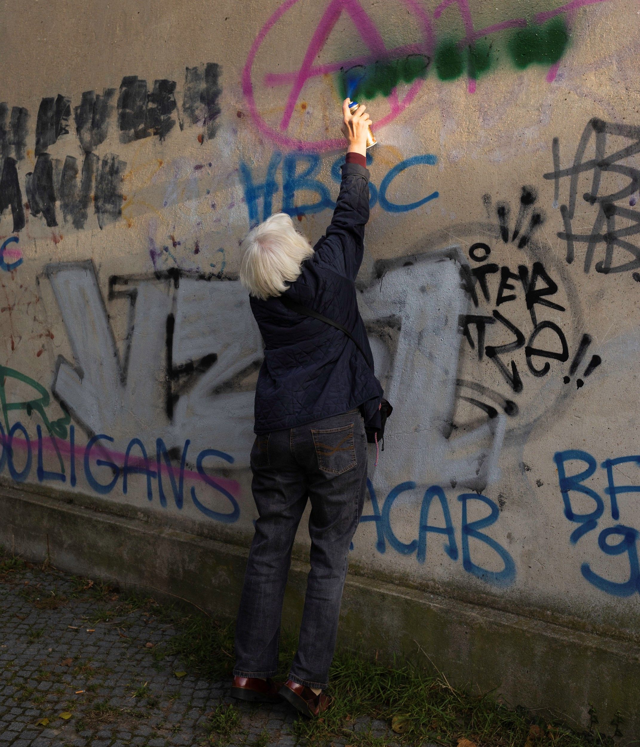 Irmela Mensah-Schramm entfernt Naziparolen an einer Wand weg