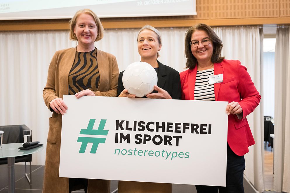 Lisa Paus und Heike Ullrich halten ein Schild auf dem "Klischeefrei im Sport" steht. Verena Bentele hält einen Ball.