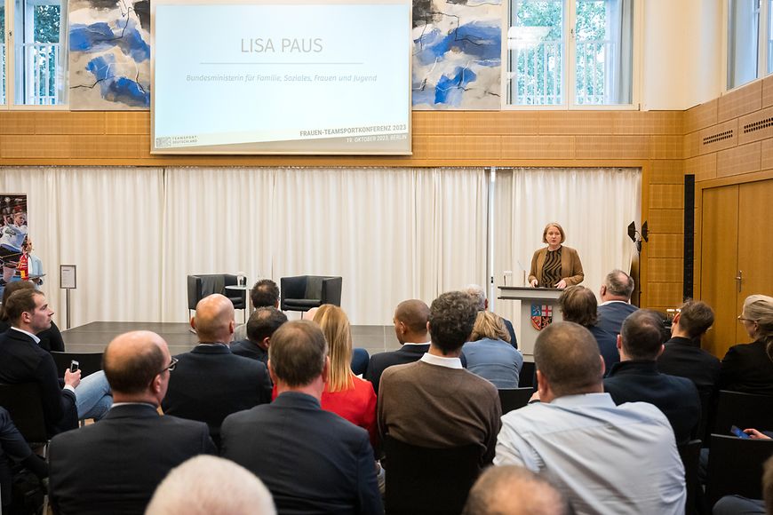 Lisa Paus steht an einem Rednerpult vor Publikum.