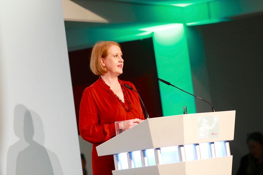 Lisa Paus steht an einem Pult und hält eine Festrede
