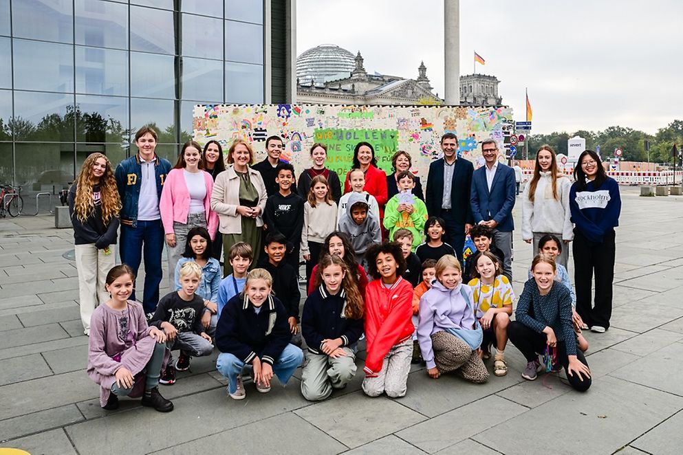 Lisa Paus mit Kindern und Jugendlichen vor dem Kinderrechte-Puzzle am Deutschen Bundestag