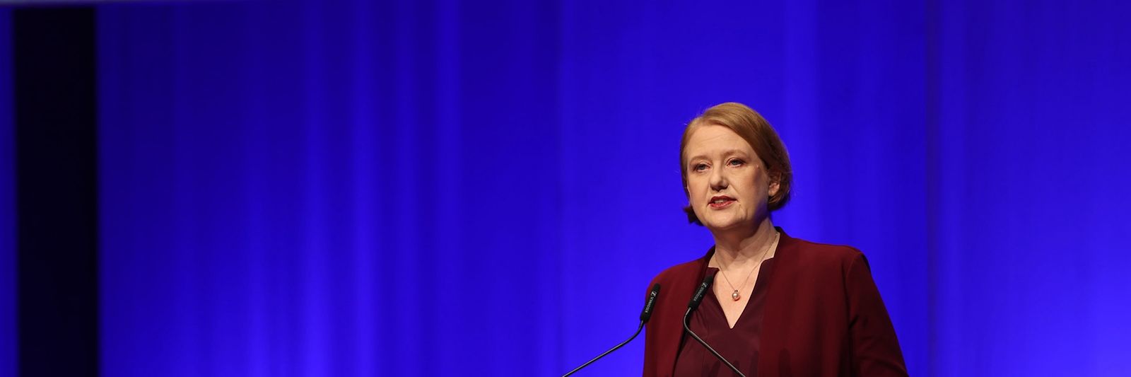 Lisa Paus steht vor einem Pult und hält einen Vortrag