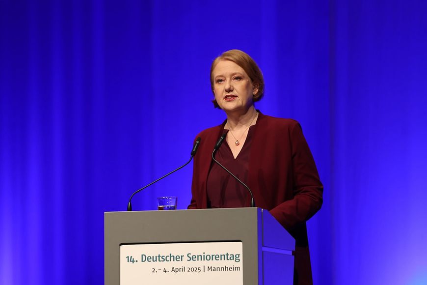Lisa Paus steht vor einem Pult und hält einen Vortrag