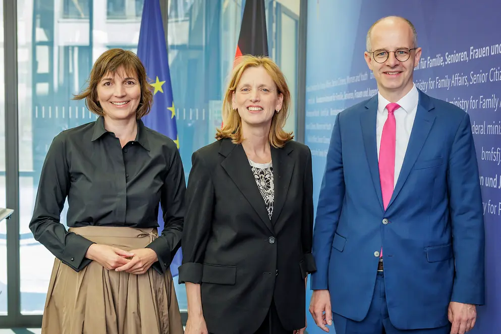 Karin Prien mit Mareike Wulf und Michael Brand vor einer Wand mit Urkunden 