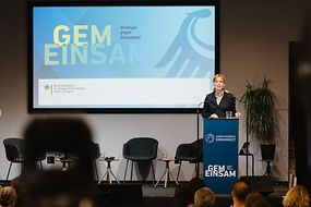 Karin Prien steht vor einem Pult und hält einen Vortrag