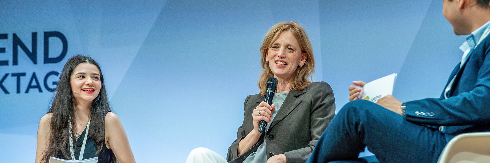 Karin Prien sitzt mit weiteren Teilnehmenden der JugendPolitikTage auf einer Bühne 