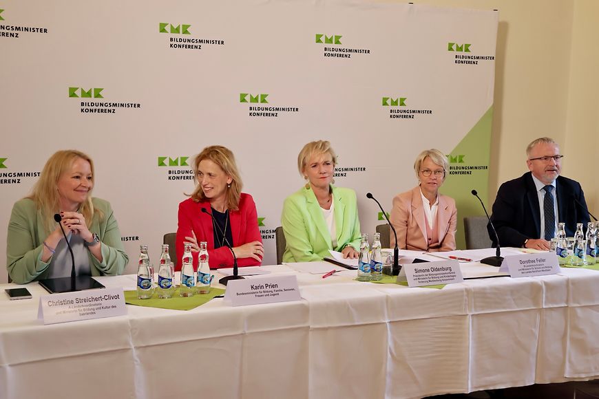 Karin Prien sitzt mit den Teilnehmenden der Bildungsministerkonferenz an einem Tisch