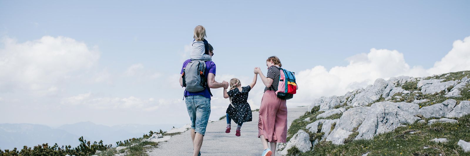 Eine junge Familie im Urlaub beim Wandern auf einen Berg